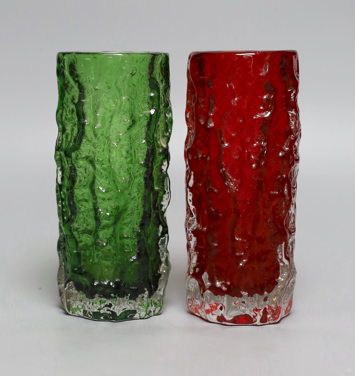Two Whitefriars 'bark' cylinder vases, model 9689, designed by Geoffrey Baxter, in red and green glass, each 19cm high.